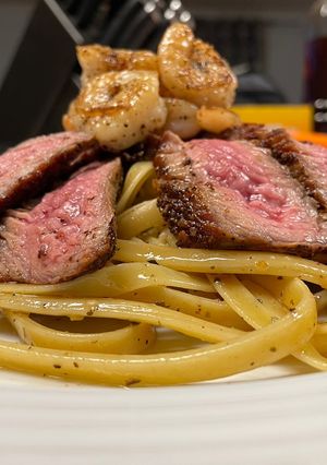 A picture of Surf n’ Turf over Garlic Basil Fettuccine.