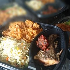 A picture of Fried and jollof rice with fried fish and meat.