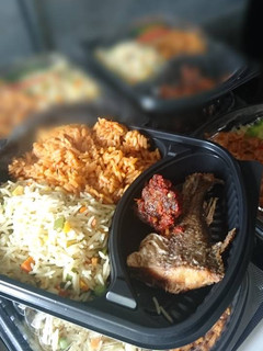 A picture of Fried and jollof rice with fried fish and meat.