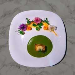 A picture of Mole verde de puerco y mousse de frijol blanco.