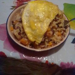 A picture of Rice and beans served with filed egg.
