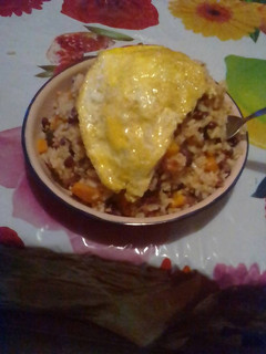 A picture of Rice and beans served with filed egg.