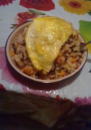 A picture of Rice and beans served with filed egg.