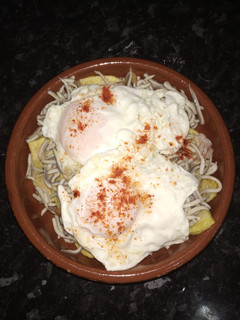 Una foto de Huevos rotos con gulas y gambas