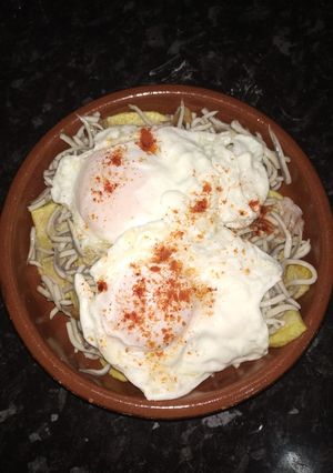 Una foto de Huevos rotos con gulas y gambas