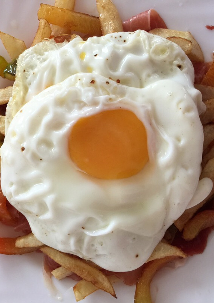 Una foto de Huevos rotos con jamón