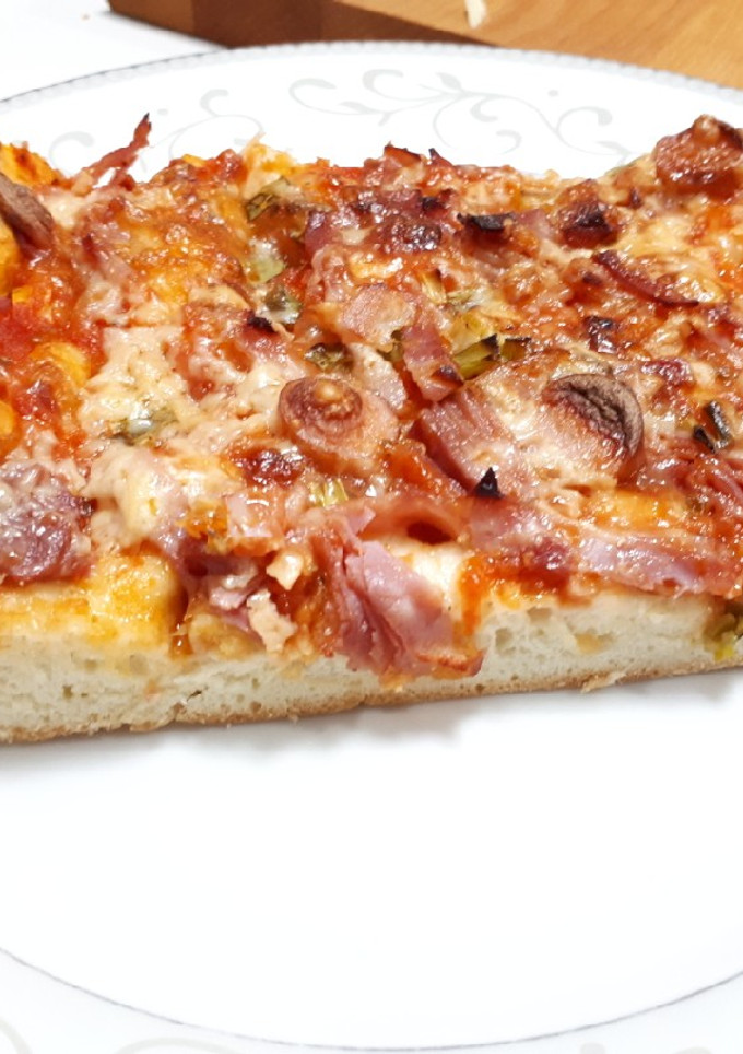 Una foto de Pizza con lacón y salchichas ahumadas