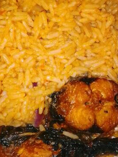 A picture of Jollof rice with fried fish.