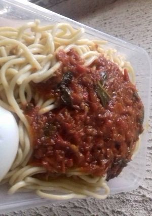 A picture of Spagetti with boiled egg and tomatoes stew.