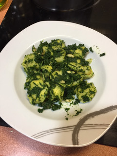 Una foto de Tortellini con espinacas y piñones