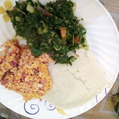 A picture of Ugali served with srambled egg and some vegetables.