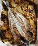 Txitxarrito al horno en cama de patatas y cebolla
