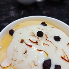 A picture of Kesar badam mug cakes with shrikhand frosting.