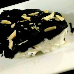 A picture of Ice cream cake with chocolate sauce.