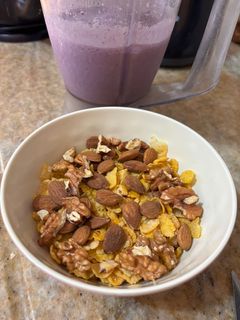 Una foto de Desayuno saludable. Cereales, frutos, leche, banana, arándanos, polvo proteico