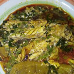 A picture of Okra soup garnished with fish and pomo.