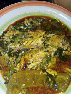A picture of Okra soup garnished with fish and pomo.