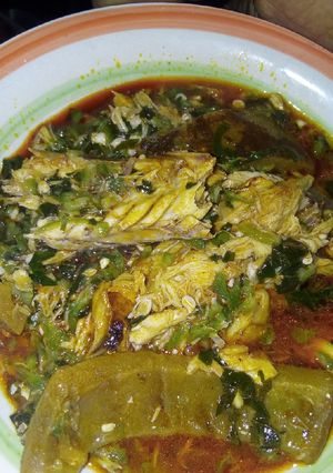 A picture of Okra soup garnished with fish and pomo.