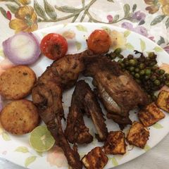 A picture of Tandoori chicken in microwave and in a pan.