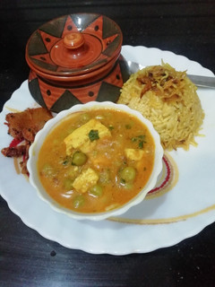 A picture of Matar Paneer with caramelized onion rice.