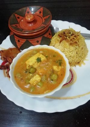 A picture of Matar Paneer with caramelized onion rice.
