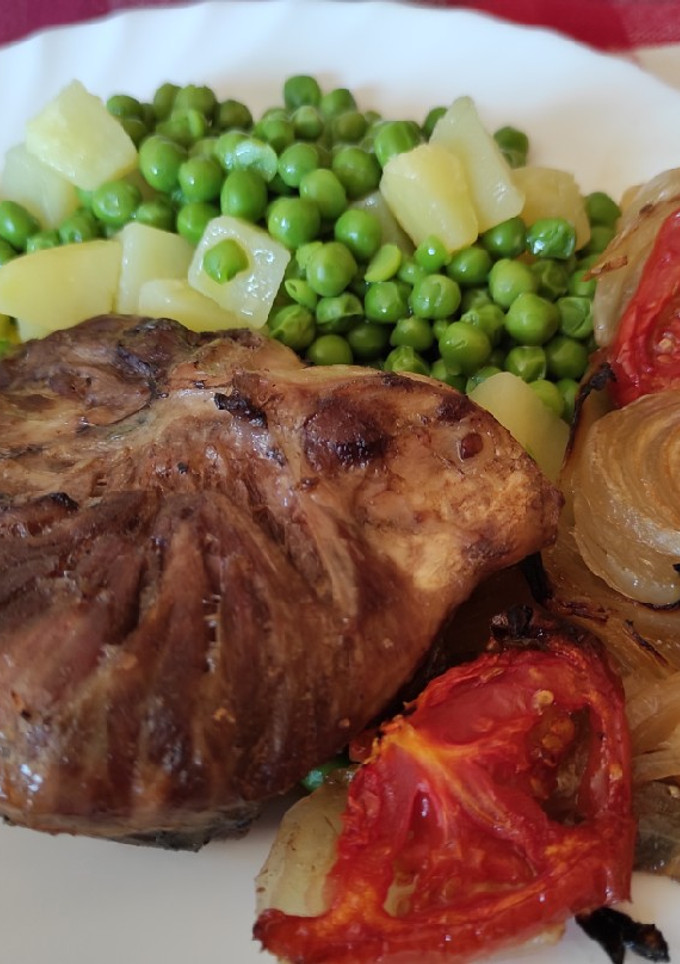Una foto de Galtes de porc con guisantes