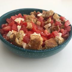 A picture of Dakos - tomato, feta and bread.