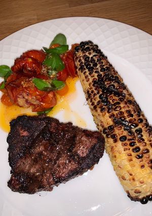 A picture of Grilled Fillet Mignon with grilled corn and roasted garlic tomatoes 🍅.