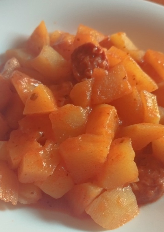 Una foto de Papas con chorizo picante y vino blanco