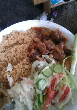 A picture of Oxtail with butter beans tomato and basil cous cous with salad.