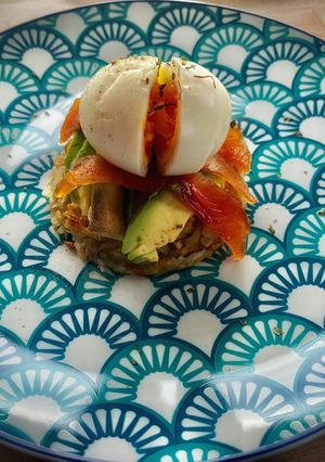 Una foto de Tortita de patatas con aguacate, salmón y huevo poché