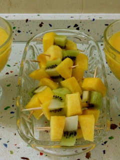 Una foto de Smoothie de caqui y mandarina con pinchitos de melocotón y kiwi