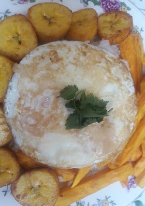 Una foto de Huevo frito con arroz blanco, bastones de camote y bananas🇵🇪