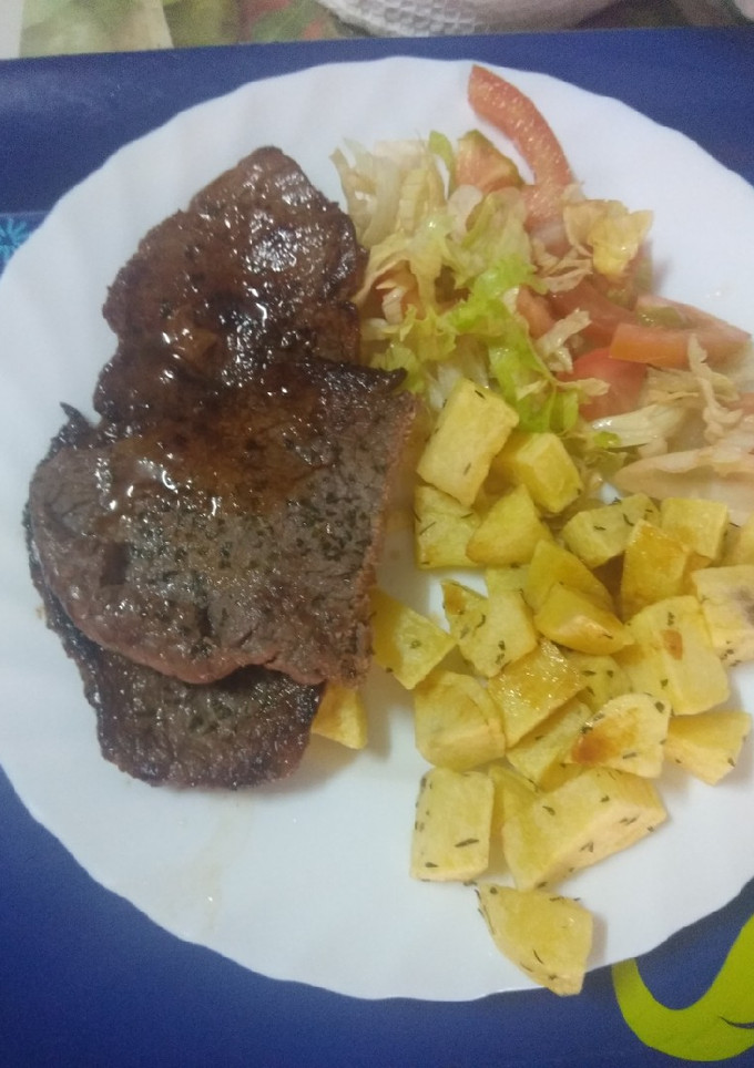 Una foto de Filetes con papas fritas aromatizadas y ensalada