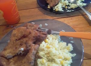 Una foto de Milanesa de pescado y arroz con azafrán y choclo