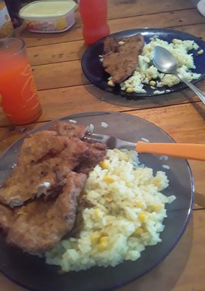 Una foto de Milanesa de pescado y arroz con azafrán y choclo