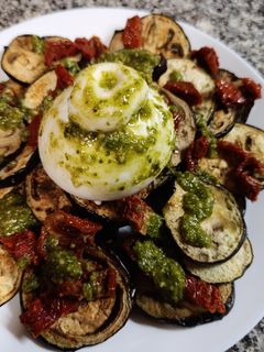 Una foto de Berenjena asada con burrata, pesto y tomate seco