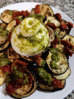 Una foto de Berenjena asada con burrata, pesto y tomate seco