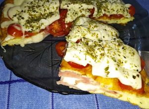 Una foto de Soufflé simil pizza en sartén cobertura de tomates cherrys y queso