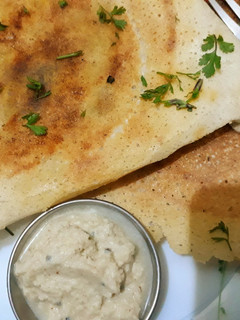 A picture of Masala Dosa with Coconut Chutney.