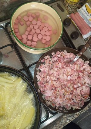 Una foto de Papas con cheddar panceta y salchichas 🐷