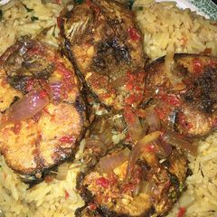 Local jellof rice with peppered fish A picture of Local jellof rice with peppered fish.
