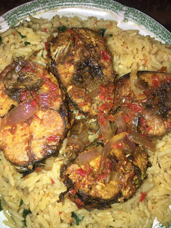 A picture of Local jellof rice with peppered fish.