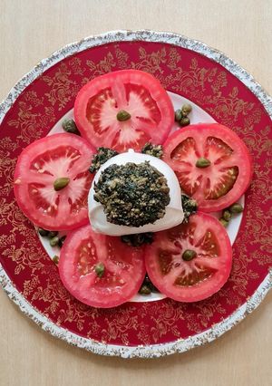 Una foto de Ensalada de tomate, polpetta, alcaparras y pesto casero