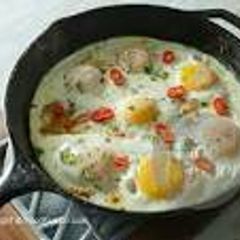 A picture of Egg breakfast with tomatoes and potatoes.