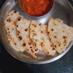 A picture of Chawal (rice) roti with tamatar (tomato) ki chutiya.