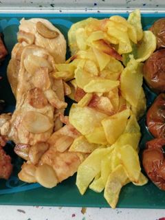 Una foto de Pollo al ajillo con patatas fritas y tomates kumato asados