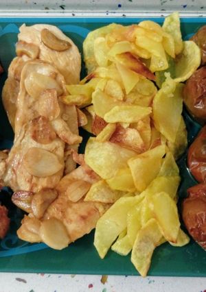 Una foto de Pollo al ajillo con patatas fritas y tomates kumato asados