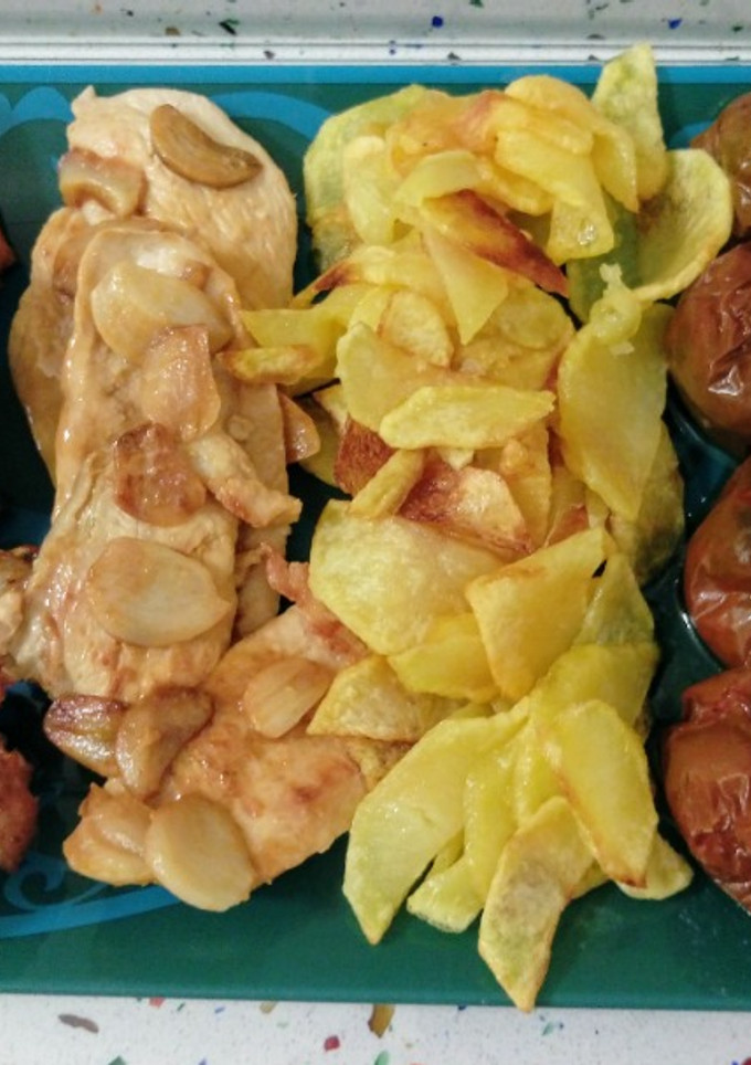 Una foto de Pollo al ajillo con patatas fritas y tomates kumato asados