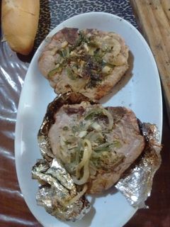 Una foto de Asado a la parrilla de chuletas de chancho a lo linyera con adobo